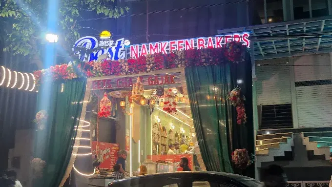 The Best Namkeen Bakers storefront lit up at night